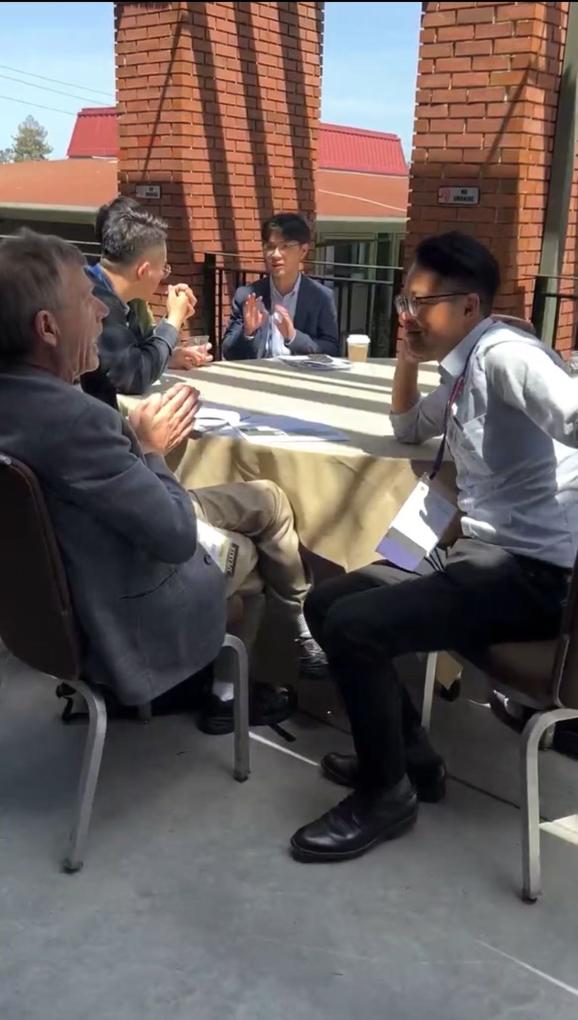 Penggao Yan talking with conference peers during a coffee break at IEEE ION PLANS 2023